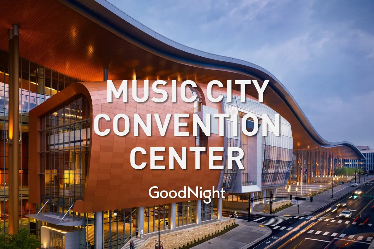 The image captures the dynamic exterior of the Music City Center, Nashville's premier convention and event venue, with its distinctive curved roofline, glass facade, and illuminated signage. The scene is lively, suggesting an atmosphere bustling with conferences, exhibitions, and community events.